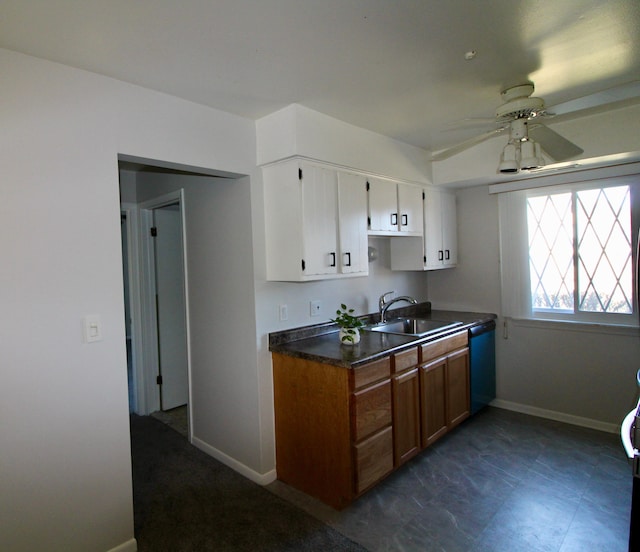 kitchen with baseboards, dishwashing machine, white cabinets, a ceiling fan, and a sink