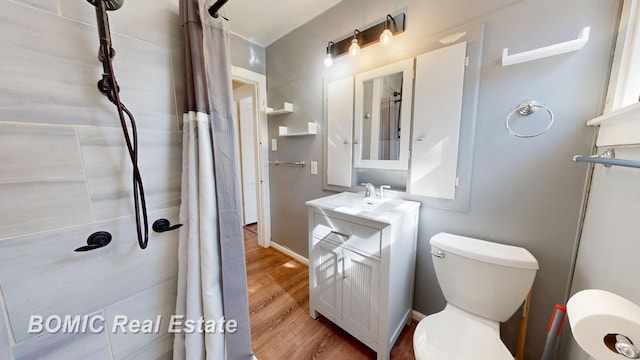 bathroom featuring vanity, wood finished floors, baseboards, curtained shower, and toilet