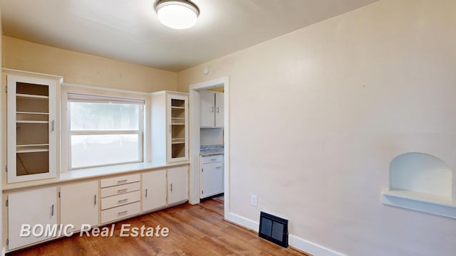 unfurnished office featuring visible vents, baseboards, and light wood finished floors