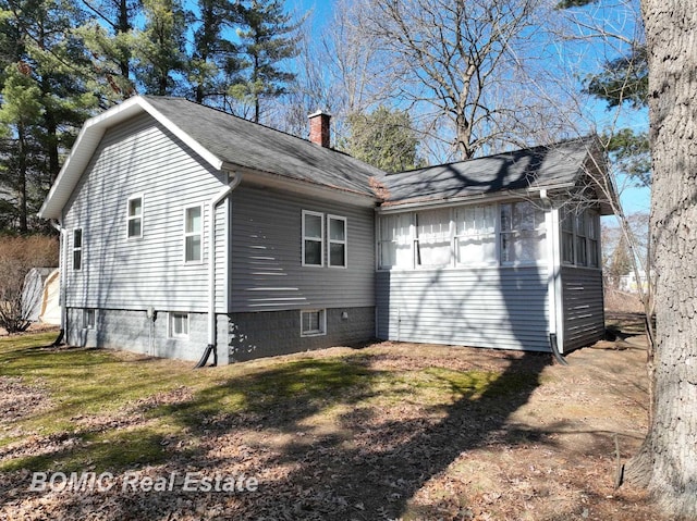 back of property featuring a chimney and a yard