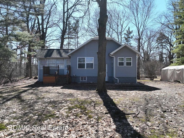 rear view of house featuring roof with shingles