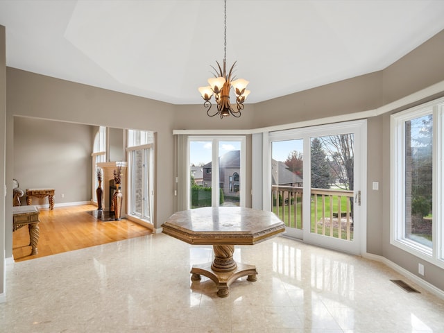 unfurnished dining area with an inviting chandelier, baseboards, and visible vents