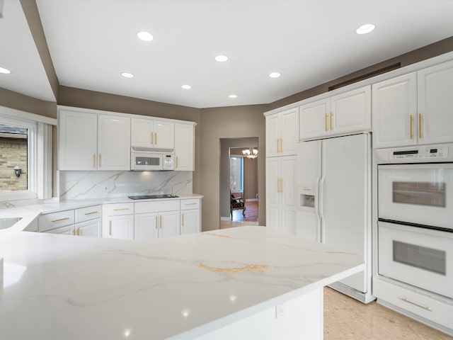 kitchen with white appliances, light stone countertops, recessed lighting, decorative backsplash, and white cabinetry