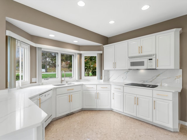 kitchen featuring a sink, backsplash, white appliances, white cabinets, and light countertops