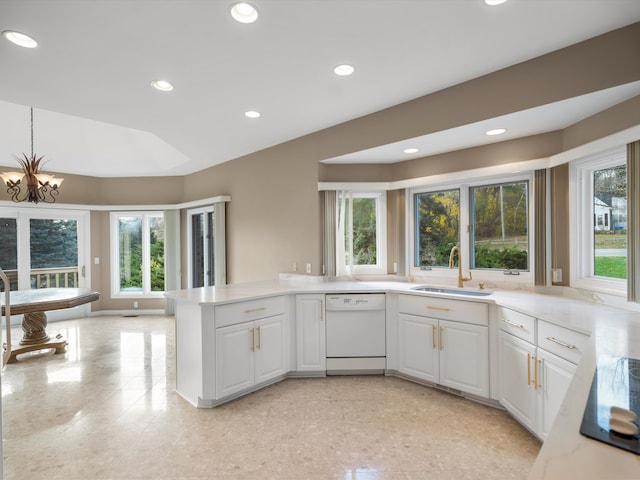 kitchen featuring dishwasher, light countertops, a peninsula, white cabinetry, and a sink