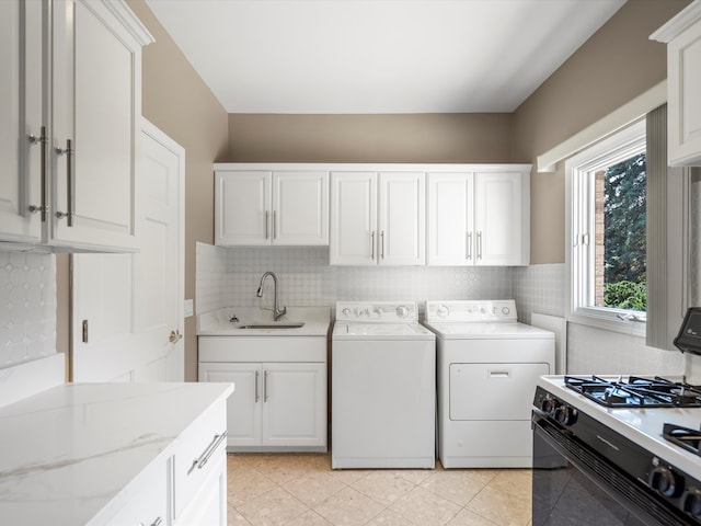 laundry room featuring a sink, separate washer and dryer, laundry area, and light tile patterned floors