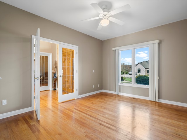 unfurnished room featuring light wood finished floors, visible vents, baseboards, french doors, and a ceiling fan