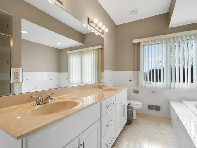 full bath with double vanity, visible vents, a stall shower, and a sink