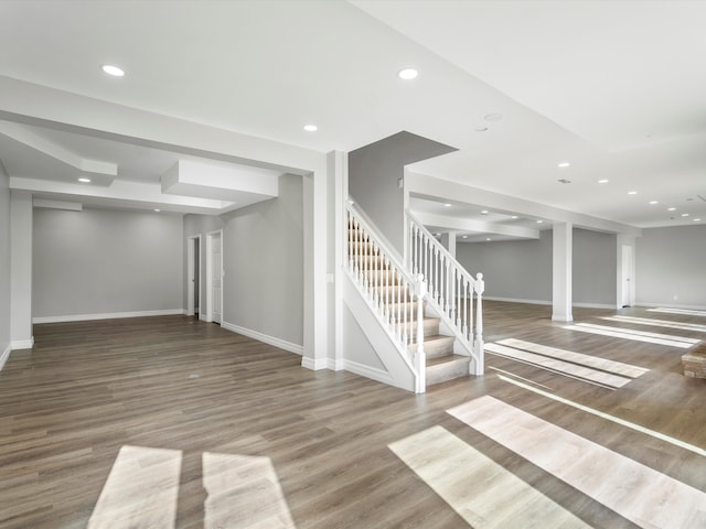 basement with stairs, wood finished floors, recessed lighting, and baseboards