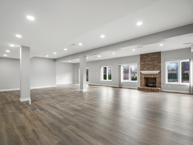 unfurnished living room featuring recessed lighting, a fireplace, baseboards, and wood finished floors