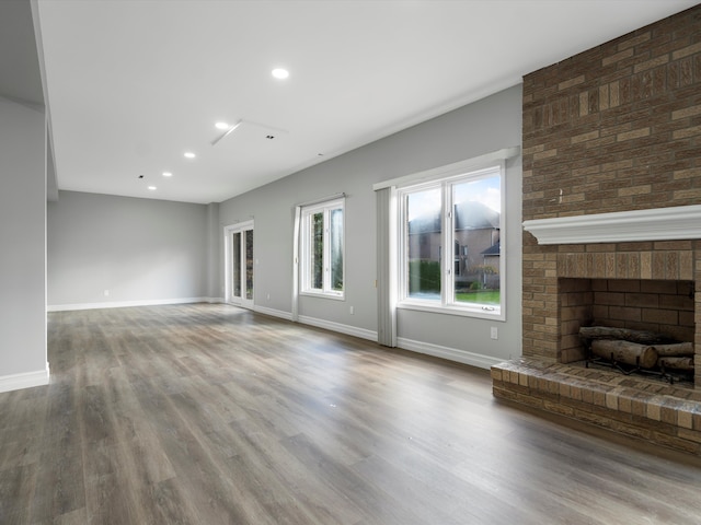 unfurnished living room featuring recessed lighting, baseboards, wood finished floors, and a fireplace