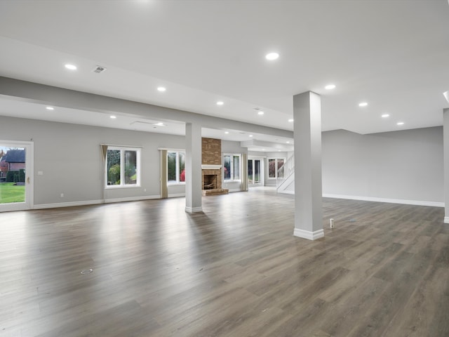 unfurnished living room with visible vents, dark wood-style floors, recessed lighting, a fireplace, and baseboards