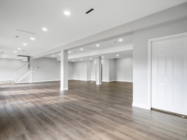 basement with recessed lighting, stairs, and wood finished floors