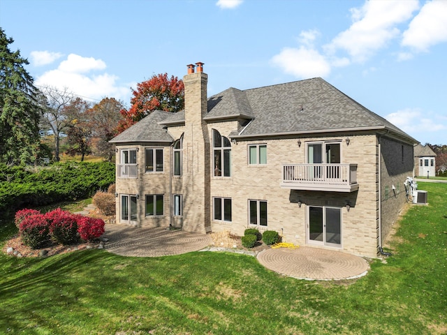 rear view of property featuring a patio area, brick siding, and a yard