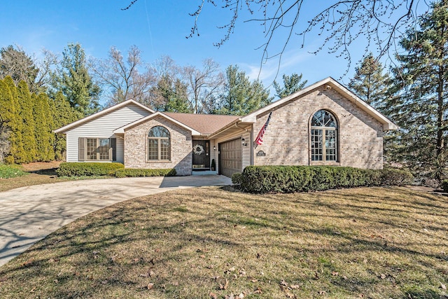 view of front of property featuring brick siding, driveway, a front yard, and a garage