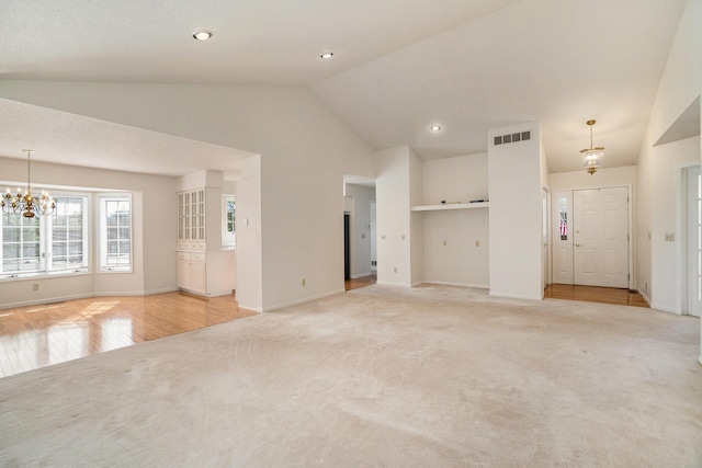 unfurnished living room with light carpet, visible vents, a chandelier, and vaulted ceiling