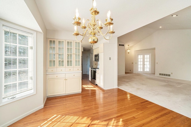 unfurnished dining area with visible vents, light wood-style flooring, french doors, and vaulted ceiling