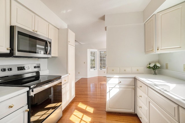 kitchen featuring light wood finished floors, white cabinetry, appliances with stainless steel finishes, and light countertops