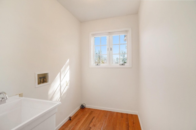 laundry area featuring a sink, light wood-style floors, baseboards, hookup for a washing machine, and laundry area