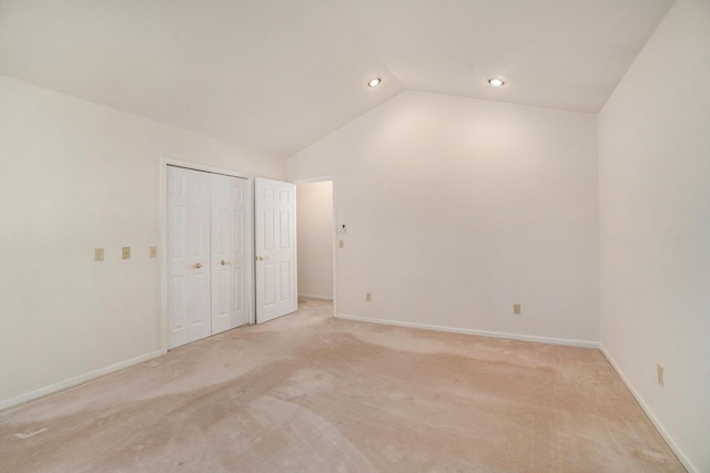 unfurnished bedroom featuring recessed lighting, a closet, baseboards, light colored carpet, and vaulted ceiling