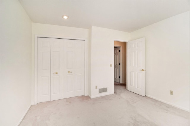 unfurnished bedroom with visible vents, light colored carpet, and baseboards