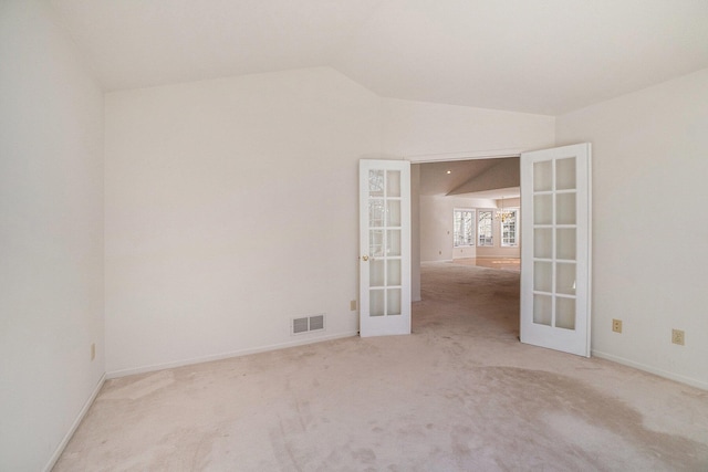 unfurnished room featuring carpet, visible vents, baseboards, lofted ceiling, and french doors