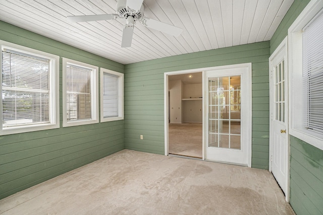 unfurnished sunroom featuring wooden ceiling and a ceiling fan