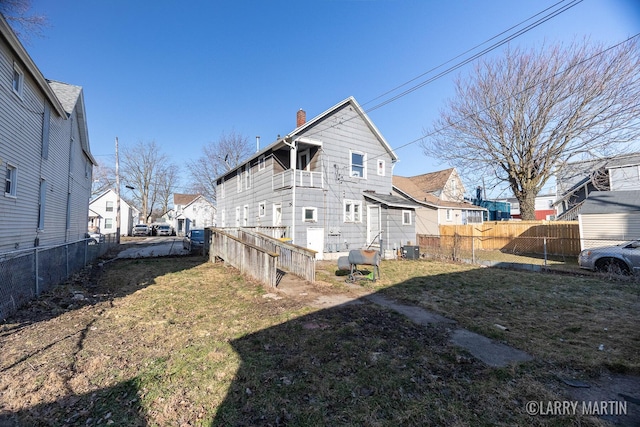 view of side of property featuring fence, a chimney, central air condition unit, a lawn, and a residential view