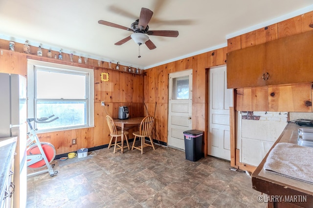 office area with wooden walls and ceiling fan