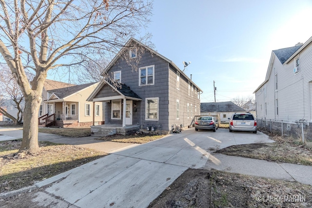 view of front of home with concrete driveway and fence