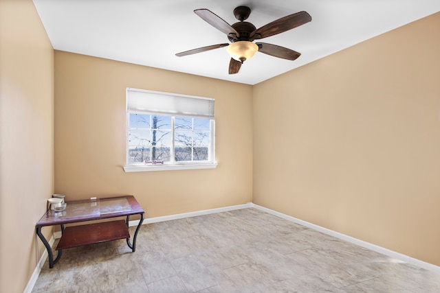 interior space with a ceiling fan and baseboards