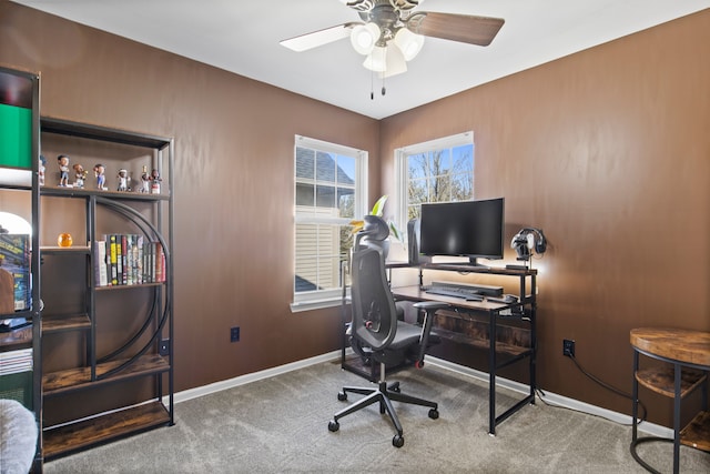 carpeted home office with ceiling fan and baseboards