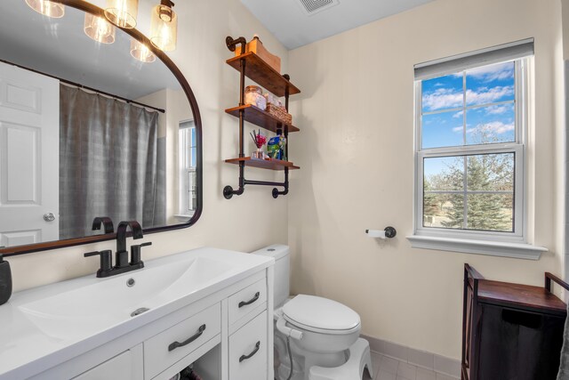 bathroom with a shower with shower curtain, toilet, vanity, and baseboards