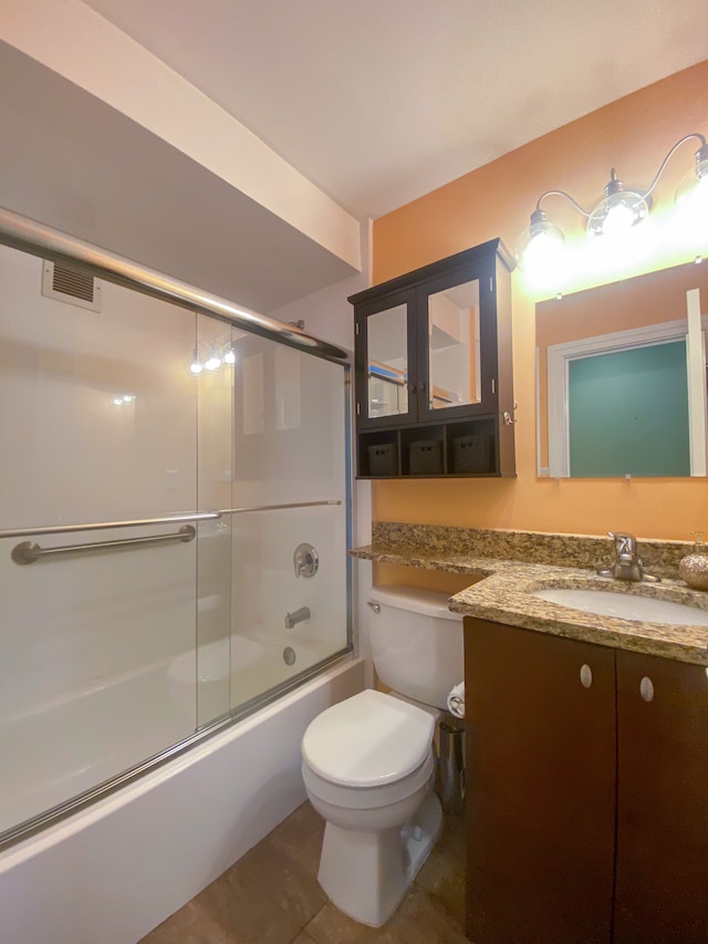 full bath with visible vents, toilet, shower / bath combination with glass door, tile patterned flooring, and vanity