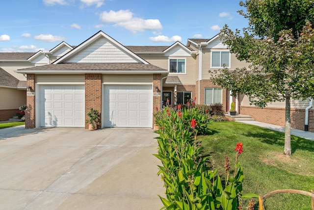 view of front of home featuring brick siding, a front lawn, concrete driveway, roof with shingles, and an attached garage