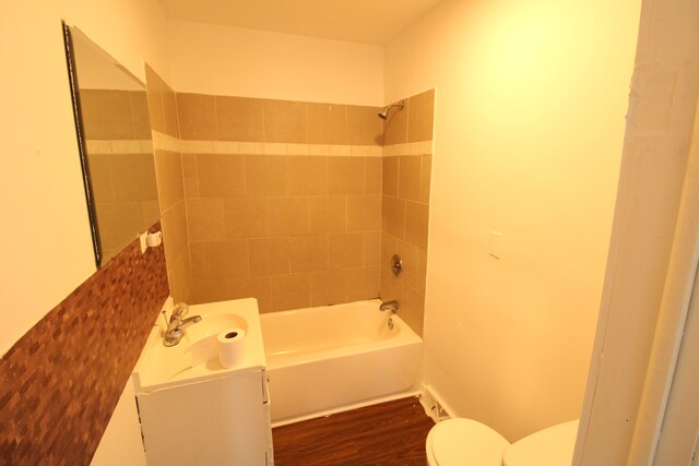 bathroom featuring vanity, toilet, bathing tub / shower combination, and wood finished floors