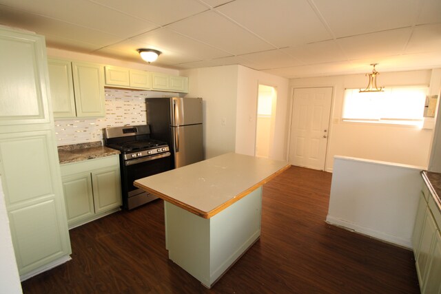 kitchen featuring dark wood-style flooring, stainless steel appliances, decorative backsplash, pendant lighting, and a center island