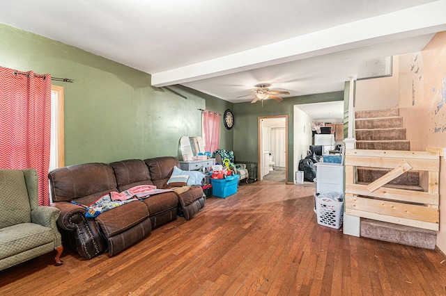 living room with stairway, beamed ceiling, a ceiling fan, and wood-type flooring