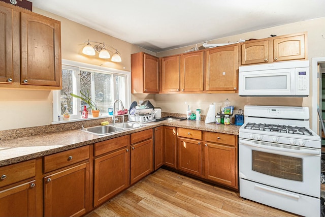 kitchen with white appliances, brown cabinets, and a sink