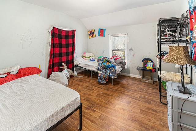 bedroom with lofted ceiling, wood finished floors, and baseboards