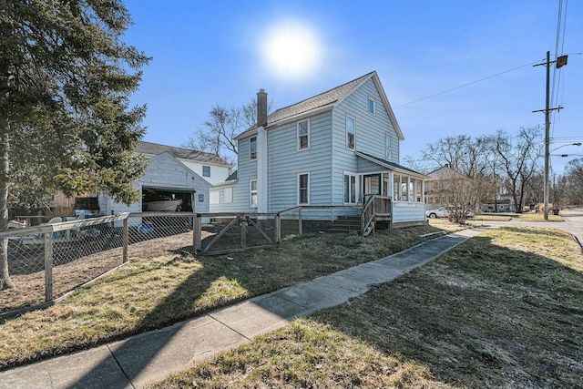 view of side of property featuring a gate, fence, a chimney, an outdoor structure, and a lawn