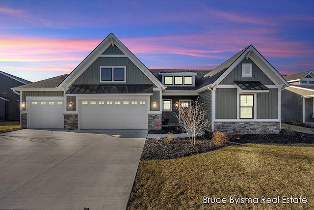 view of front of property with board and batten siding, a garage, stone siding, driveway, and a standing seam roof