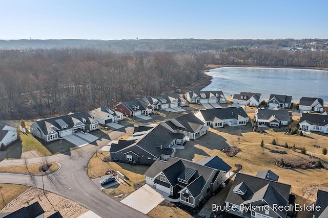 aerial view with a forest view, a residential view, and a water view