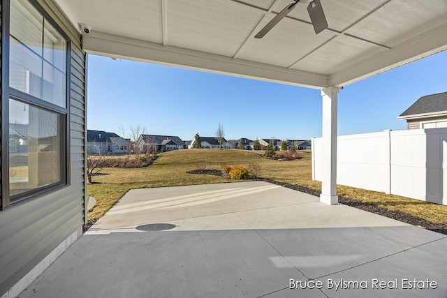 view of patio featuring a residential view, ceiling fan, and fence