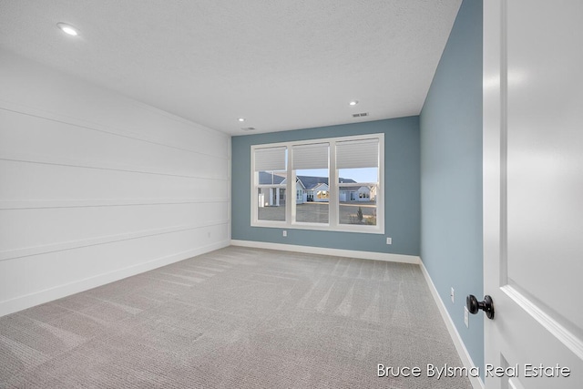 carpeted spare room with recessed lighting, visible vents, baseboards, and a textured ceiling