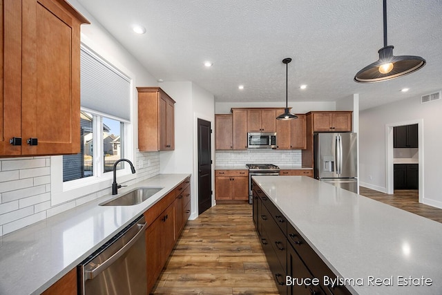 kitchen featuring a sink, visible vents, brown cabinets, and appliances with stainless steel finishes