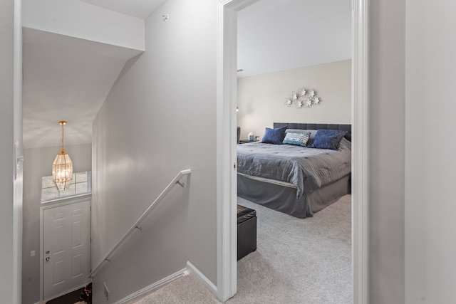 interior space featuring baseboards, an inviting chandelier, and carpet flooring