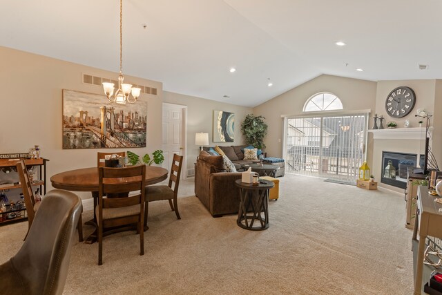 dining space with visible vents, lofted ceiling, recessed lighting, light carpet, and a glass covered fireplace