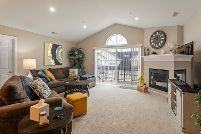 carpeted living area featuring a glass covered fireplace, lofted ceiling, recessed lighting, and visible vents