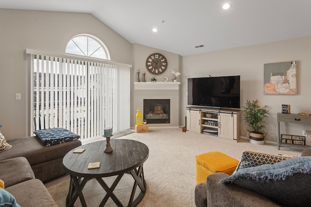 living area with visible vents, a glass covered fireplace, recessed lighting, carpet floors, and lofted ceiling